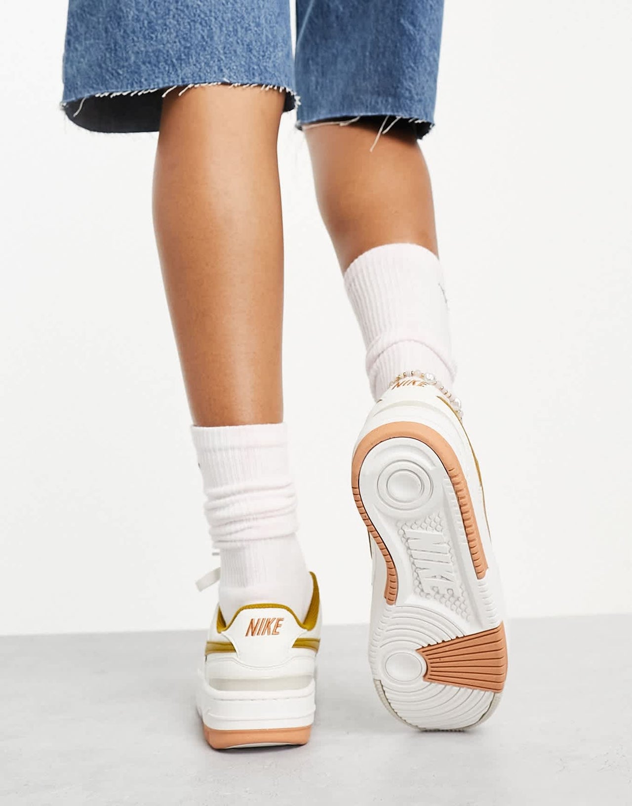 Nike Gamma Force trainers in ivory & gold