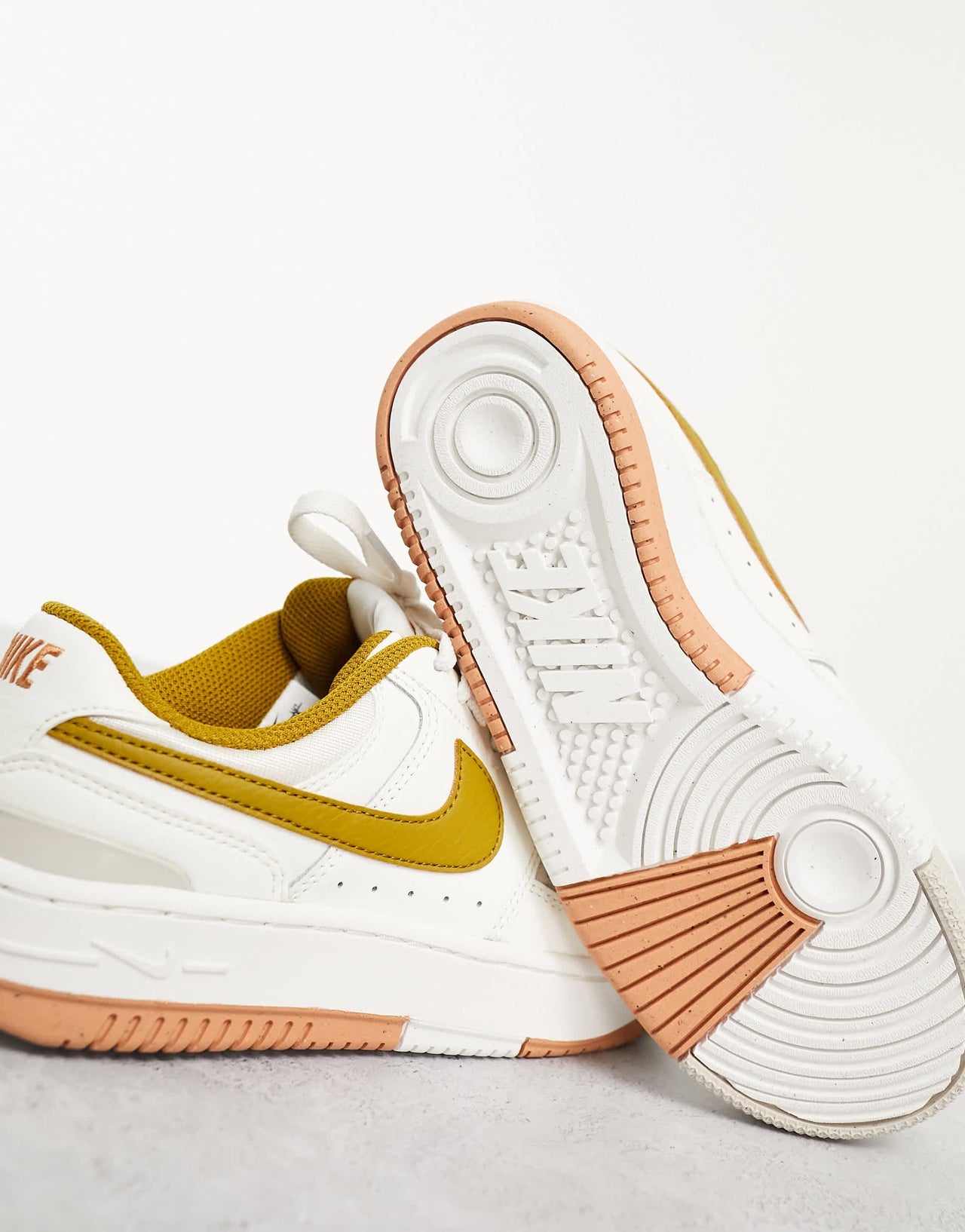 Nike Gamma Force trainers in ivory & gold