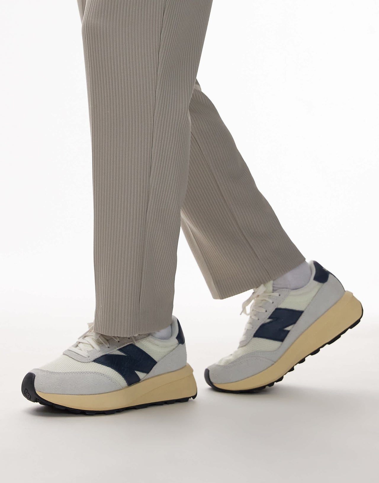 New Balance 370 trainers in white and navy