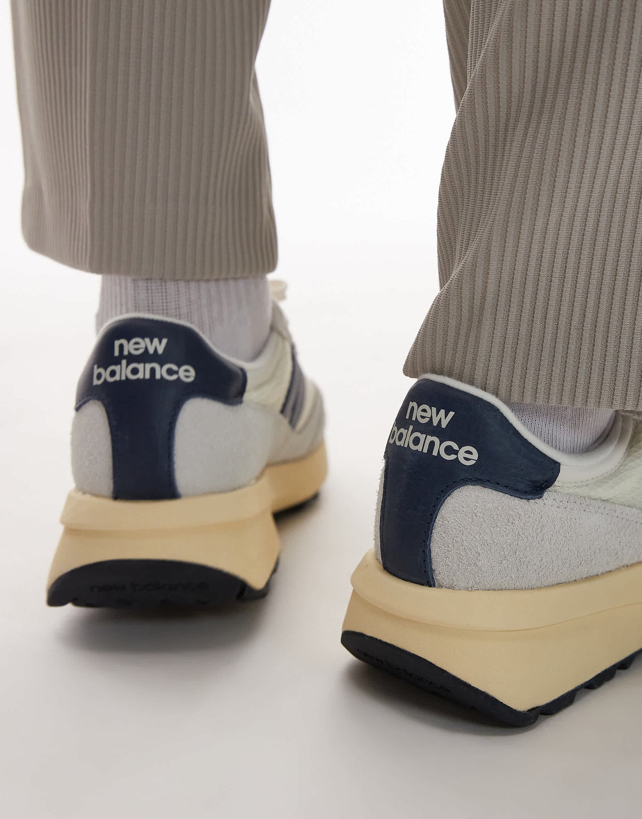 New Balance 370 trainers in white and navy