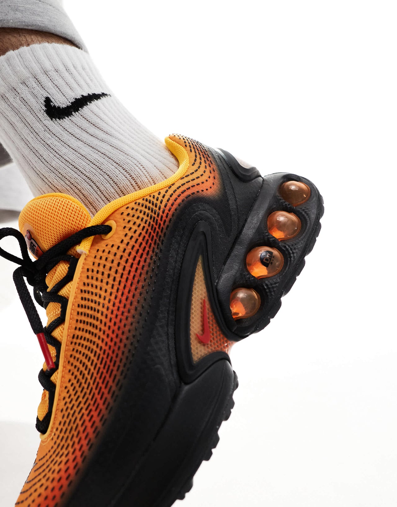 Nike Air Max DN trainers in black and orange