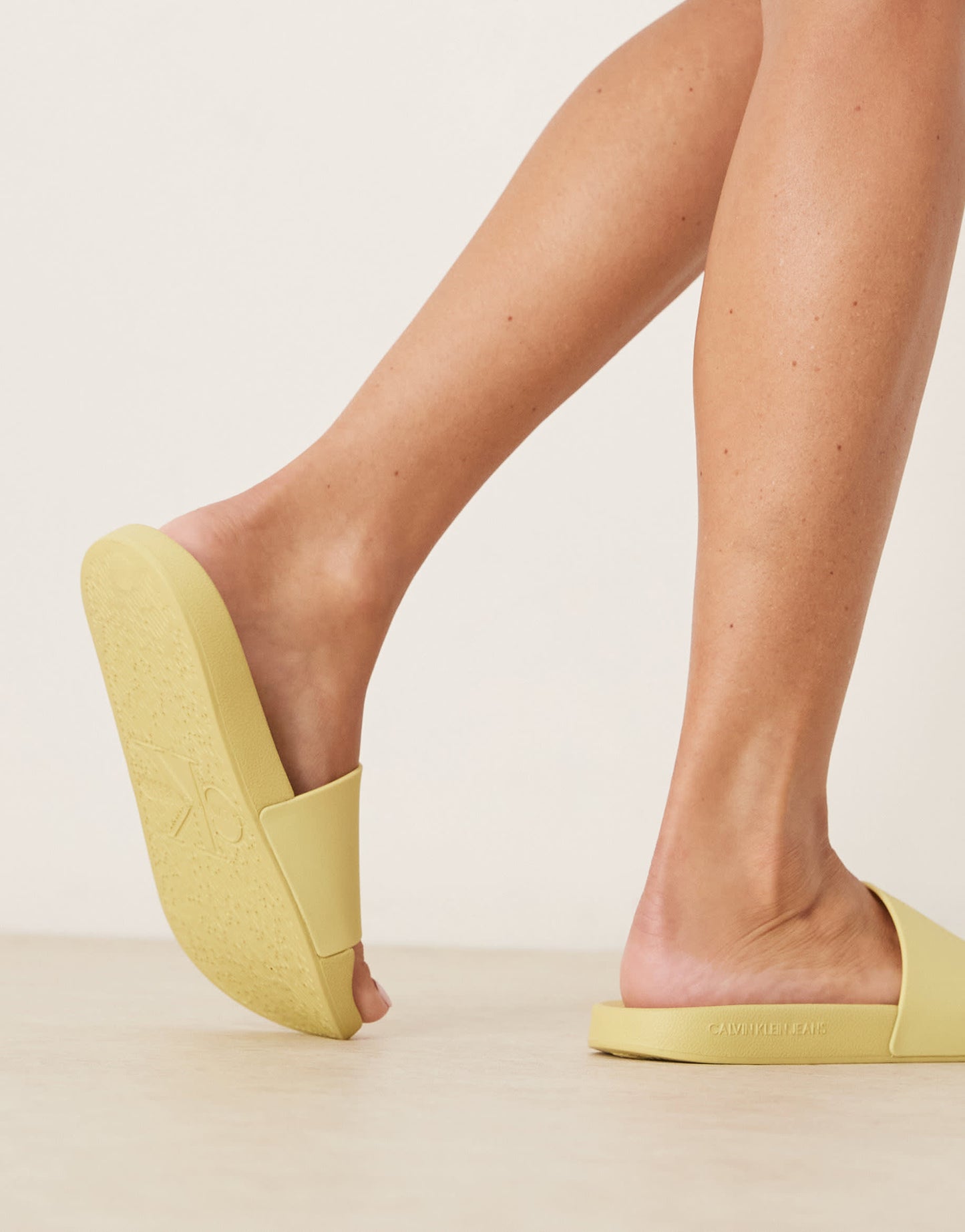 Calvin Klein monogram sliders in yellow