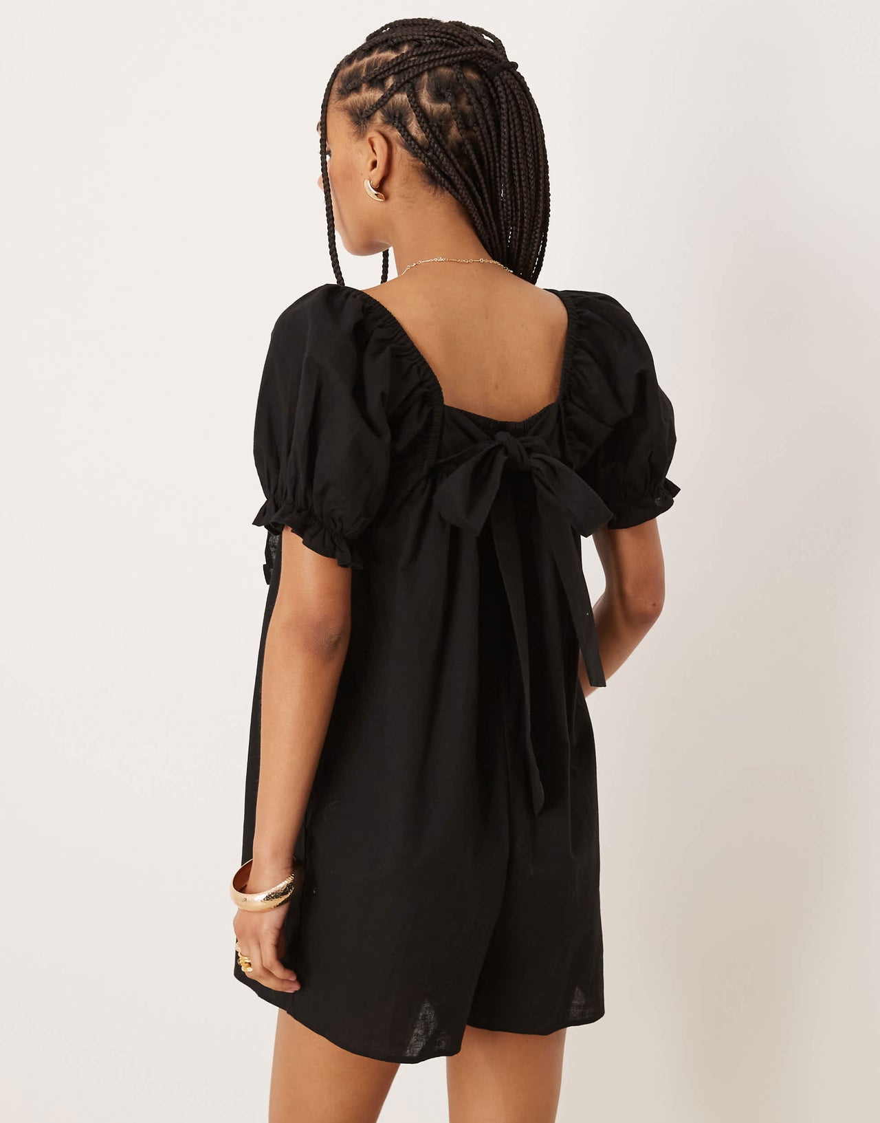 ASOS DESIGN linen babydoll puff sleeve playsuit with bow back detail in black